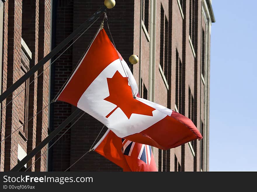 Canadian flag in front of administrative building with blue sky