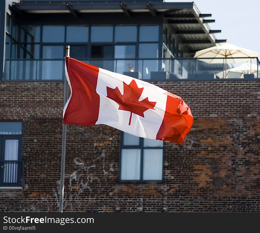 Canadian flag in front of administrative building with blue sky