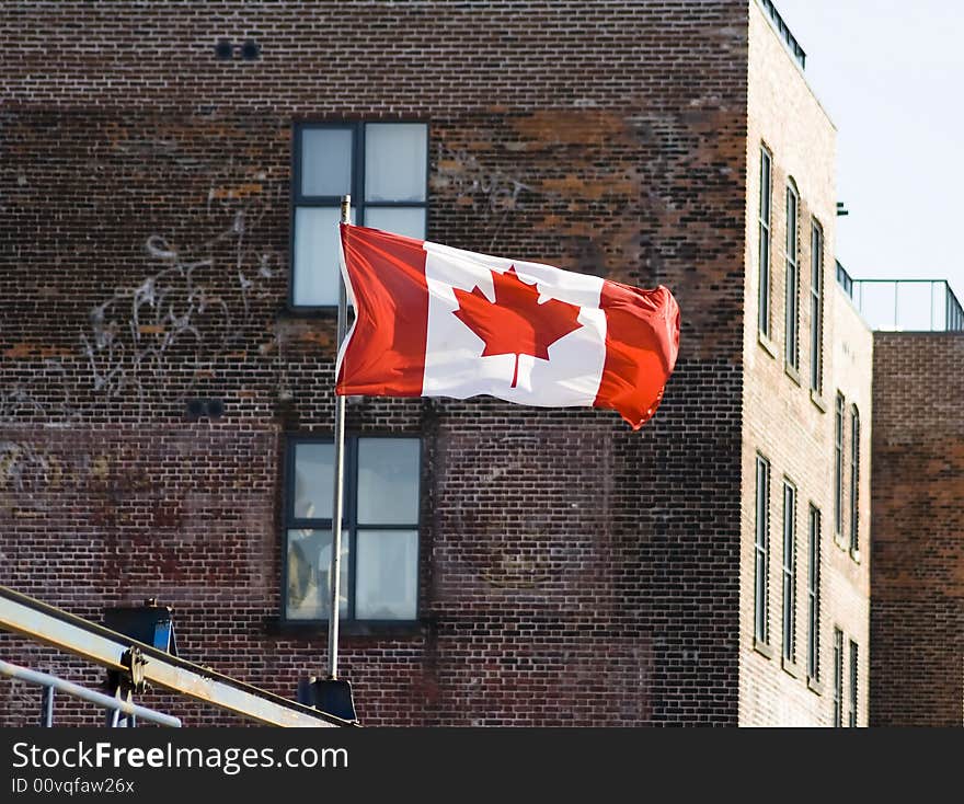 Canadian flag in front of administrative building with blue sky