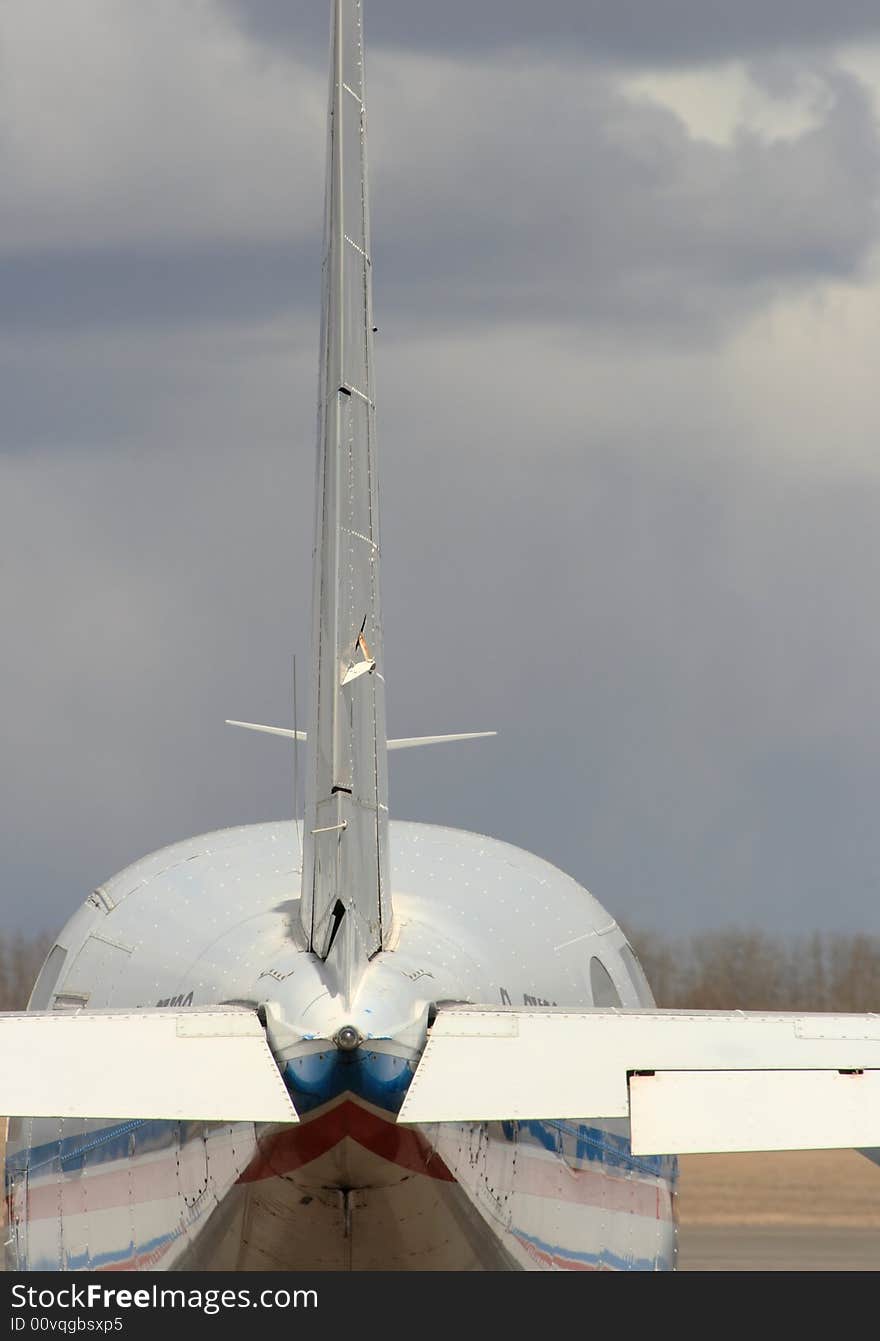 Detail of the rear section of a private plane sitting on the tarmac of an airport. Detail of the rear section of a private plane sitting on the tarmac of an airport