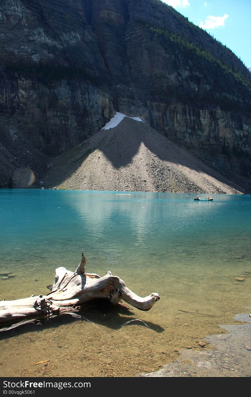 A petrified log laying near the shore of an amazing crystal blue lake in the Canadian Rockies. A petrified log laying near the shore of an amazing crystal blue lake in the Canadian Rockies