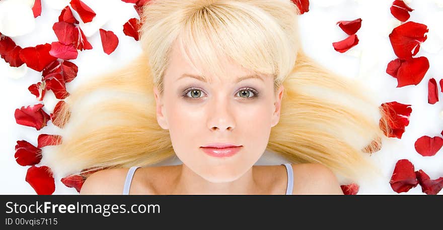 Beautiful young woman throwing rose petals against a white background. Beautiful young woman throwing rose petals against a white background