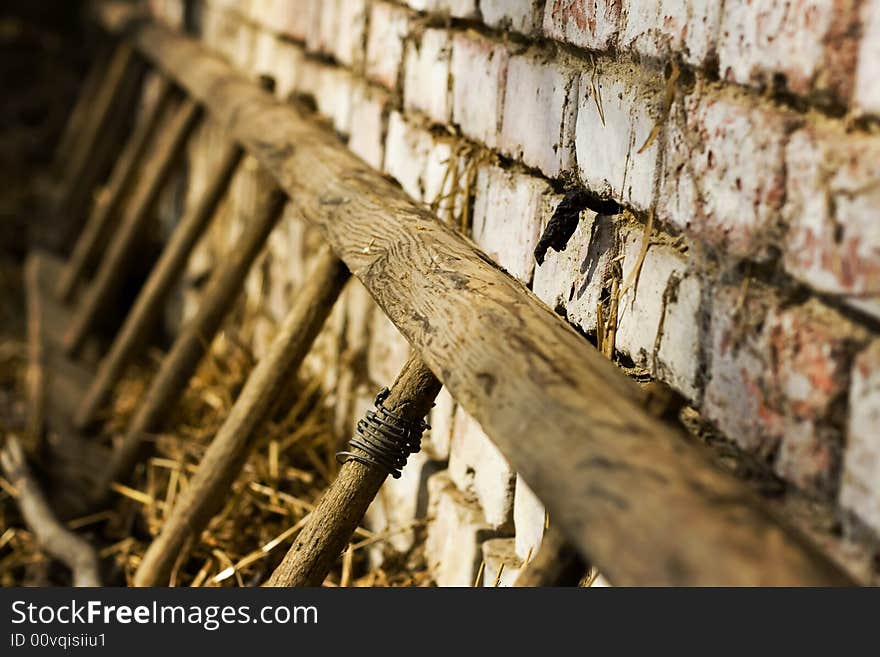 Old ladders laying on brick wall in haystack, shallow DOF