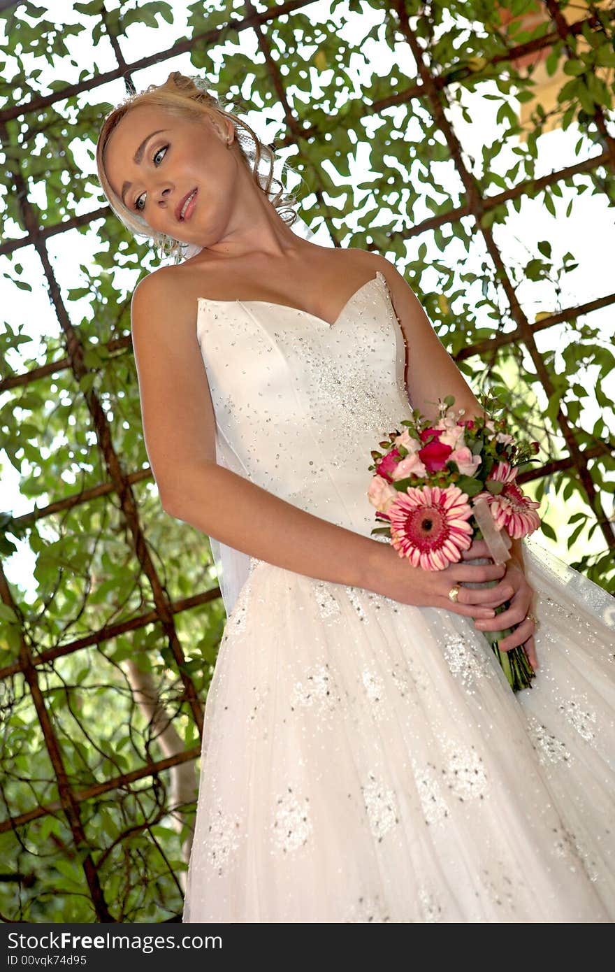 A bride standing outside in her wedding dress. A bride standing outside in her wedding dress