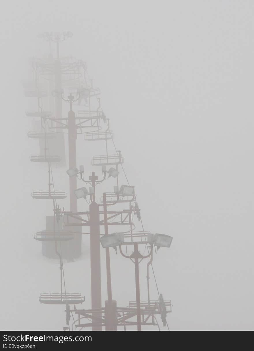 Ski Chair Lift fades uphill into the fog