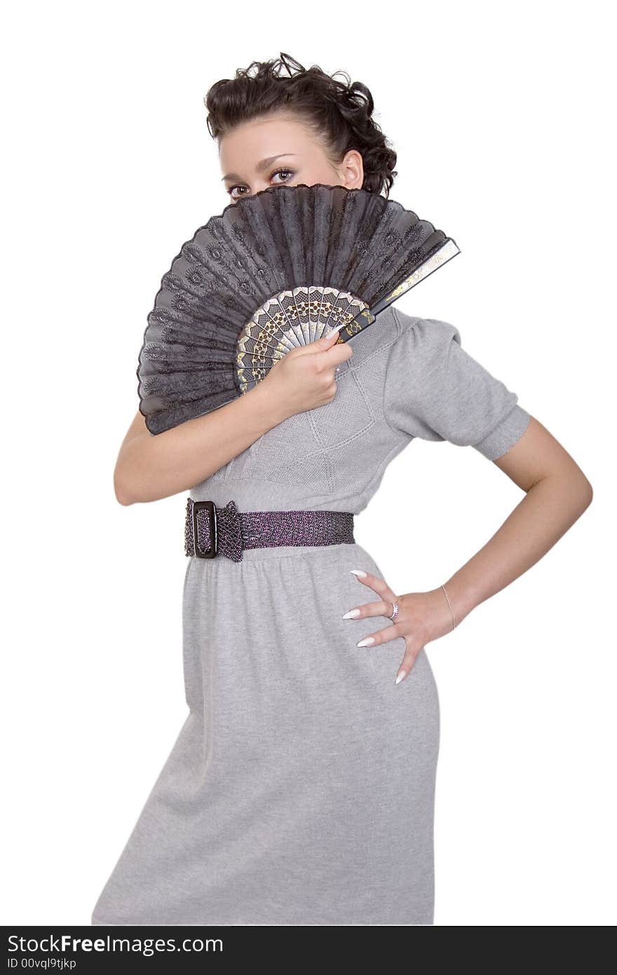 Cute brunette in grey dress with a black fan on white background. Cute brunette in grey dress with a black fan on white background