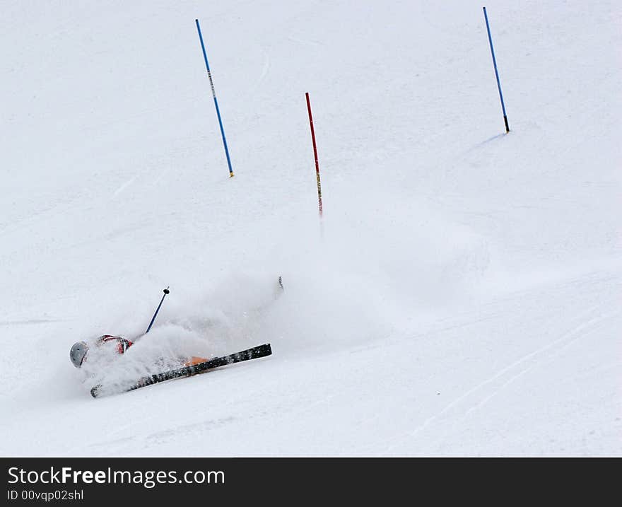 Skiier gets buried in snow kicked up from his skiis after wiping out. Skiier gets buried in snow kicked up from his skiis after wiping out