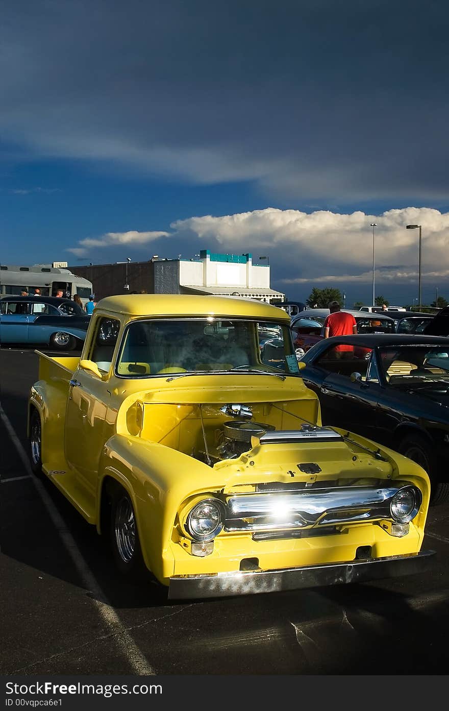 A classic 50s yellow Ford hotrod truck captured at a car show. A classic 50s yellow Ford hotrod truck captured at a car show