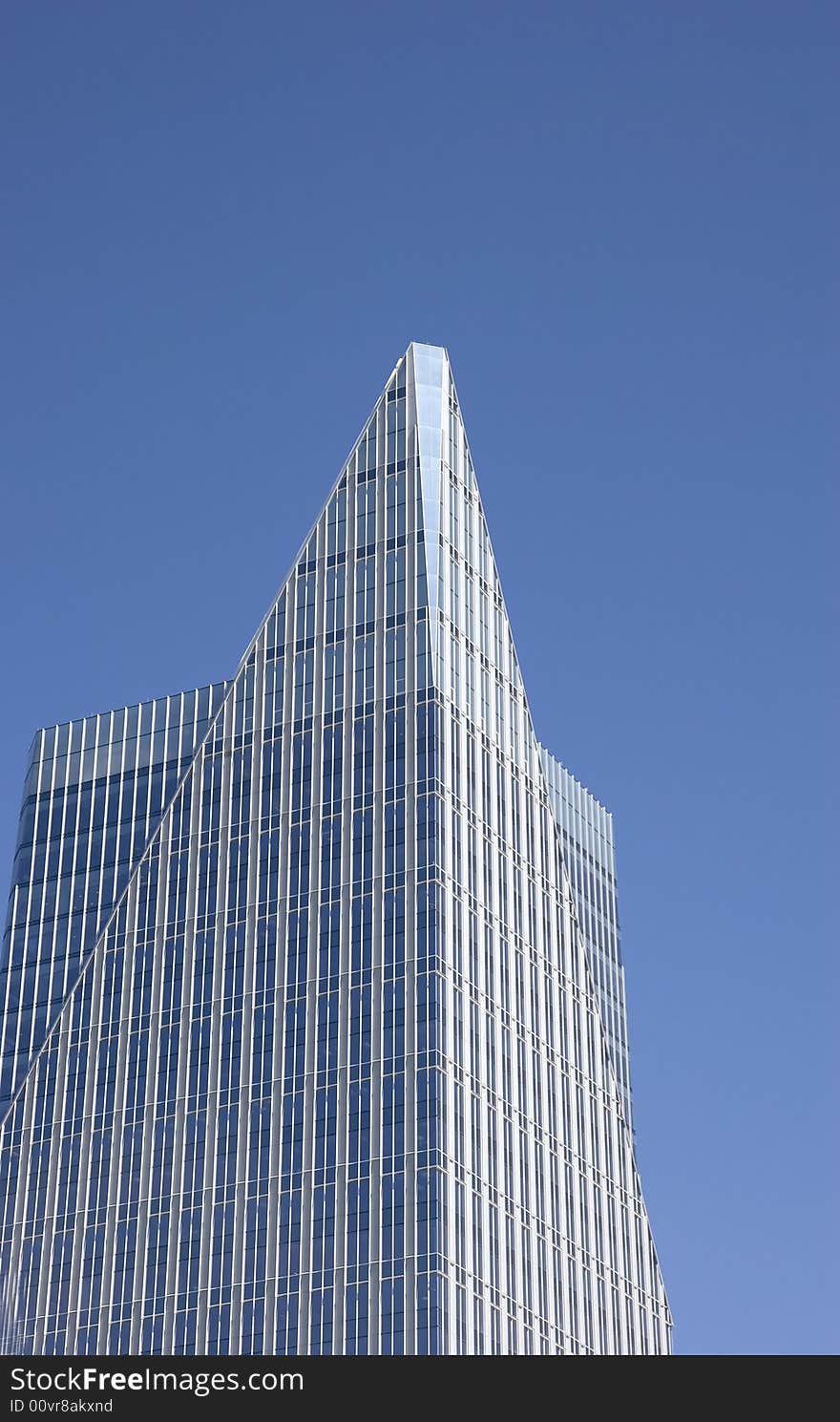 A modern blue glass office building with pyramid top. A modern blue glass office building with pyramid top