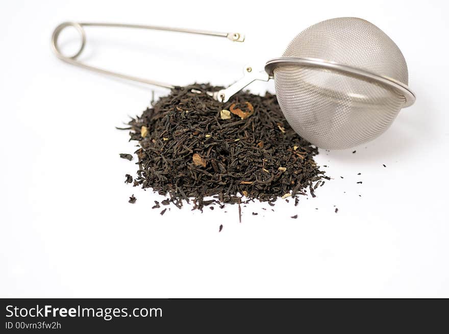 Dark tea with strainer and leaves on a white surface. Dark tea with strainer and leaves on a white surface