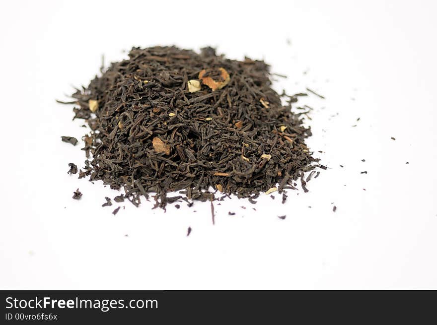 Dark tea leaves with almonds on a white surface. Dark tea leaves with almonds on a white surface