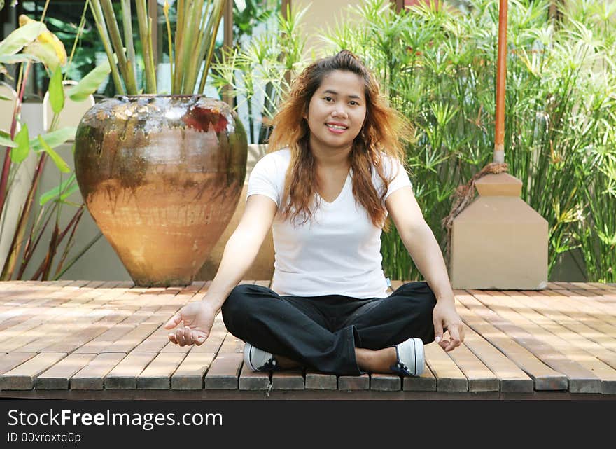 Portrait of an attractive young Thai girl sitting on a deck. Portrait of an attractive young Thai girl sitting on a deck.