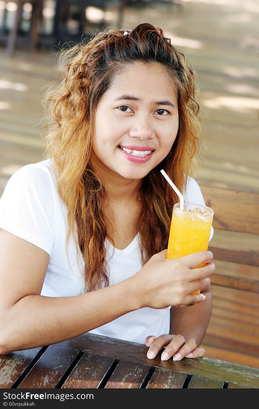 Pretty Asian girl having a drink at a cafe. Pretty Asian girl having a drink at a cafe.