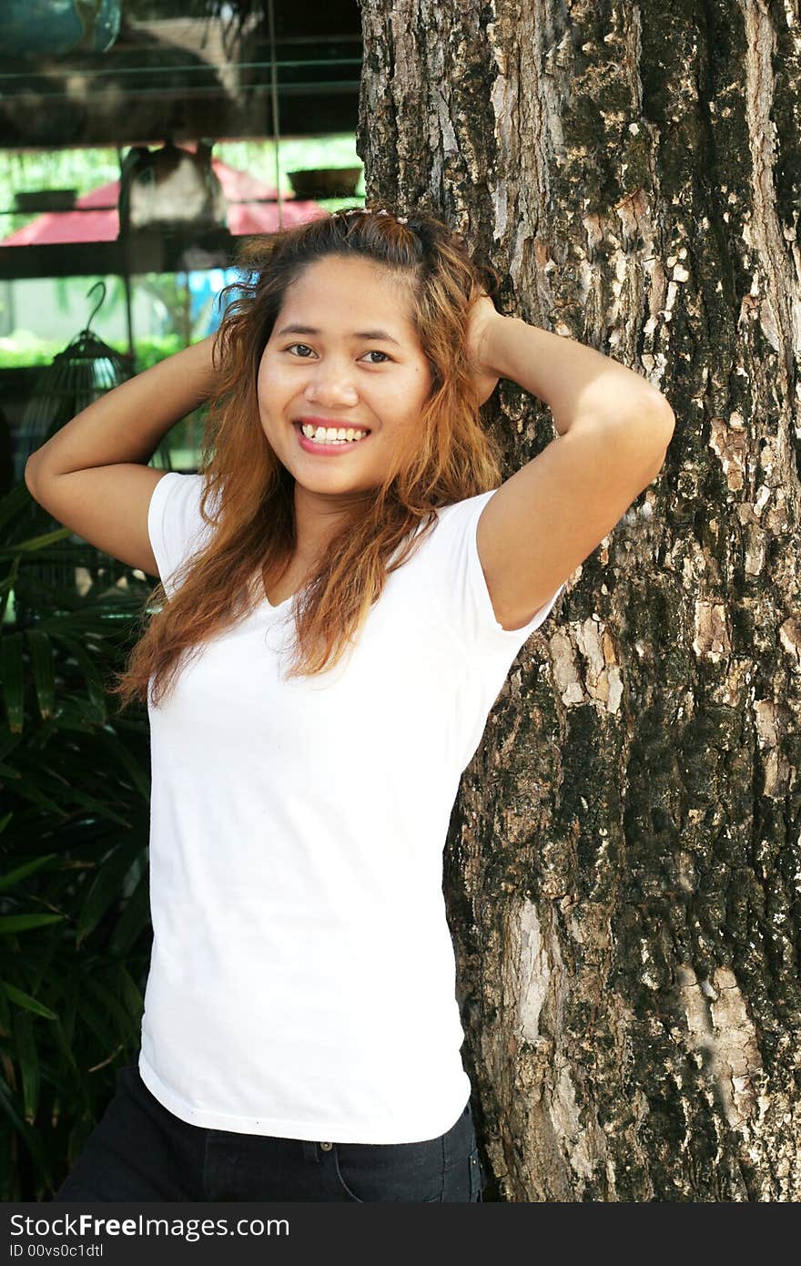 Portrait of a pretty Thai woman leaning on a tree. Portrait of a pretty Thai woman leaning on a tree.