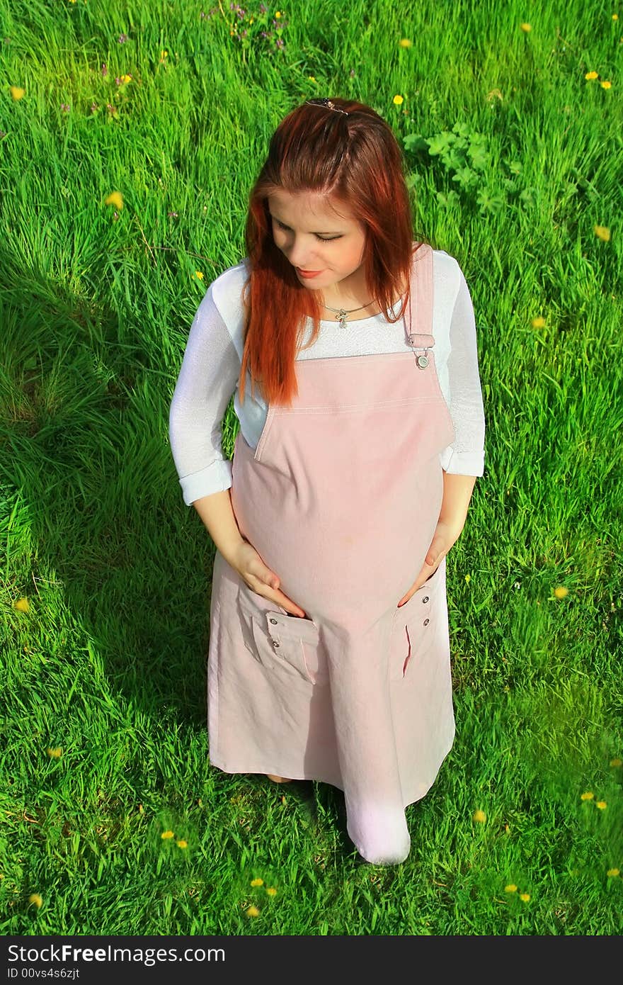 Beautiful and young pregnant girl walks on spring park: a good illustration for magazine about pregnant women and for women