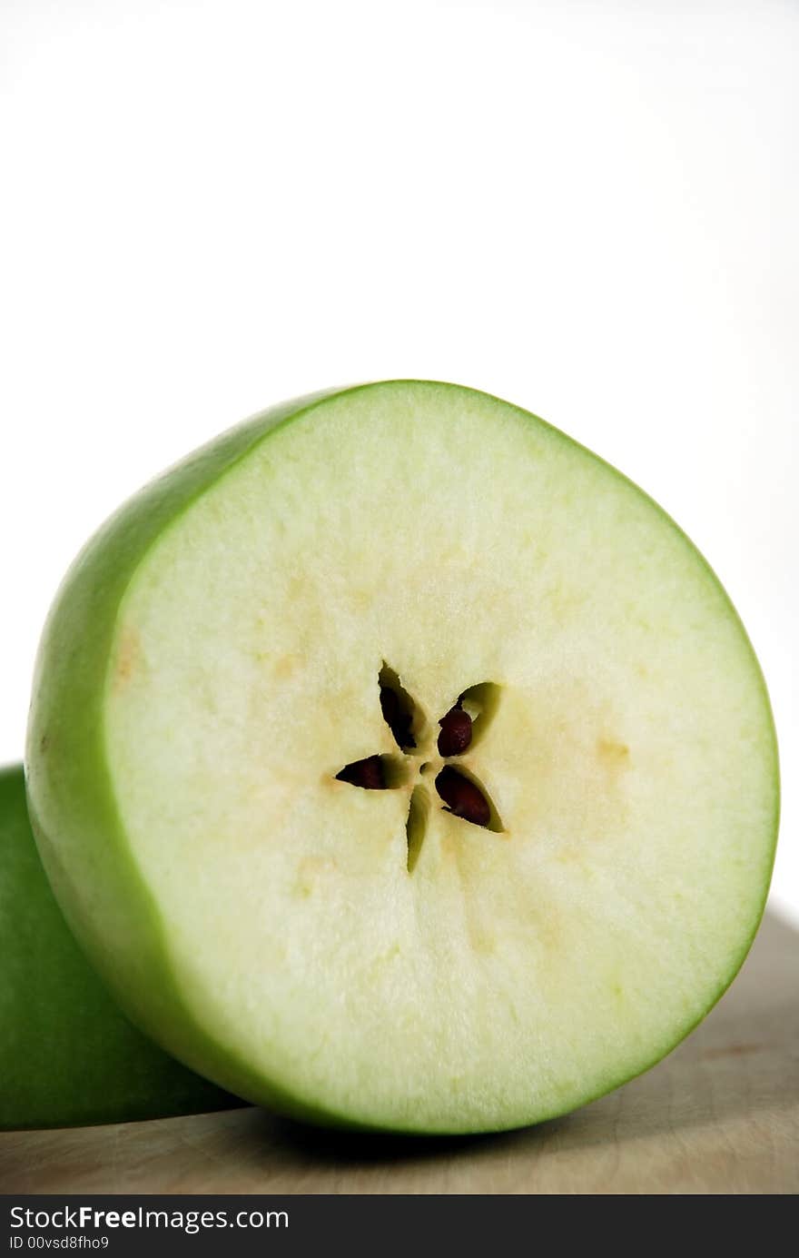 Close up to half section of cut fresh green apple on cutting board