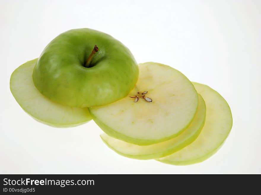 Cut fresh green apple slices are placed on each other over white