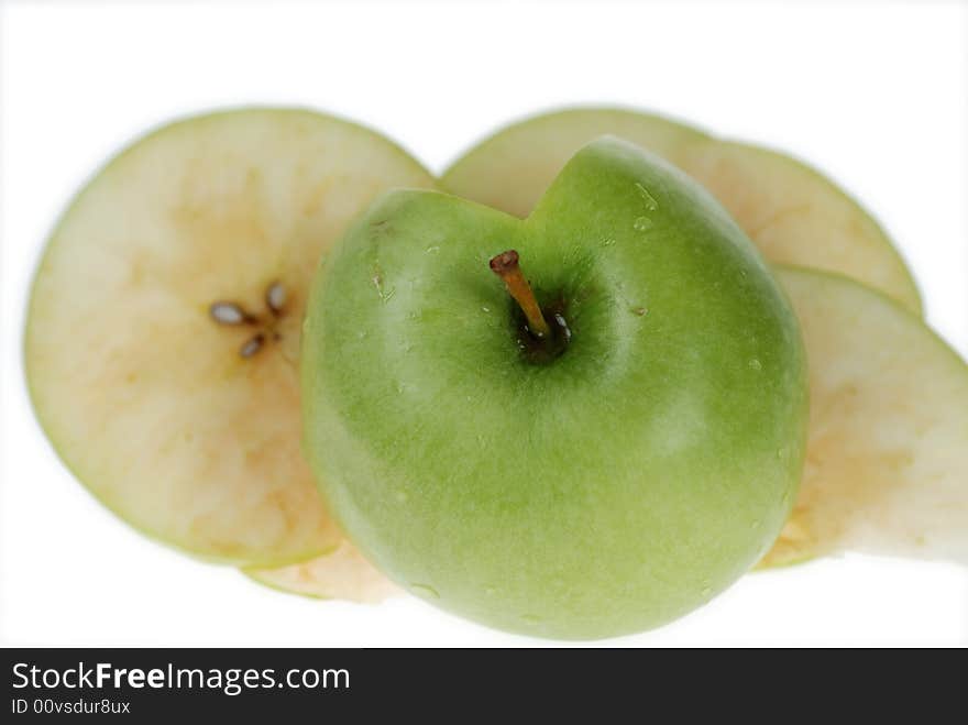 Cut fresh green apple slices are placed on each other over white