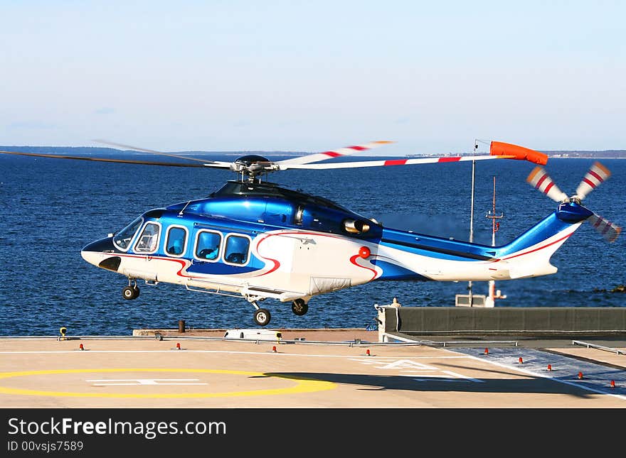 Helicopter flies up from platform near the sea. Helicopter flies up from platform near the sea.