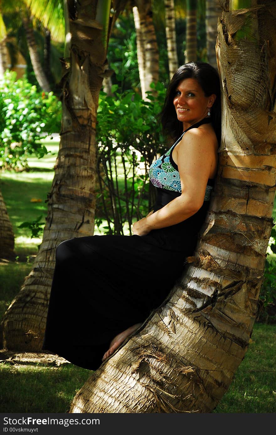 Beautiful woman posing against palm tree in a palm garden in the Dominican Republic. Beautiful woman posing against palm tree in a palm garden in the Dominican Republic