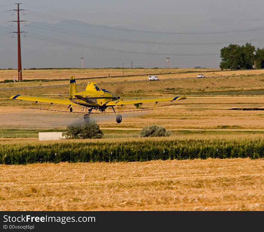 A crop dusting airplane working a corn fiel in Colorado. A crop dusting airplane working a corn fiel in Colorado