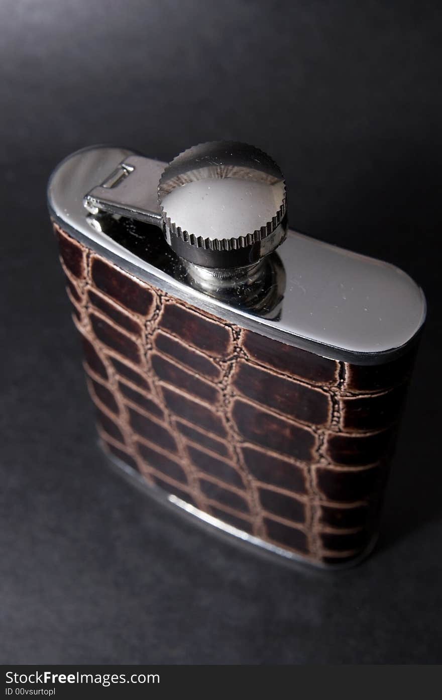 Metal flask bottle over black background