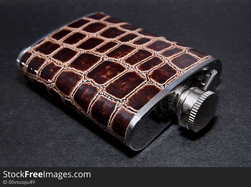 Metal flask bottle over black background