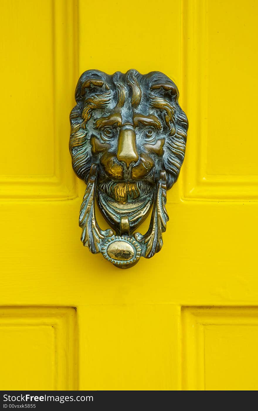 Traditional English Brass Door Knocker on a yellow door. Traditional English Brass Door Knocker on a yellow door