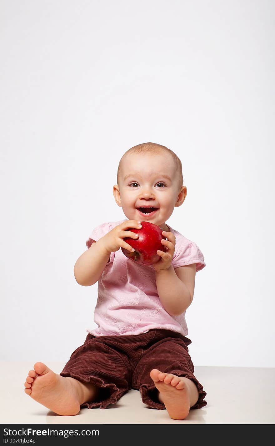 Portrait of happy baby with apple