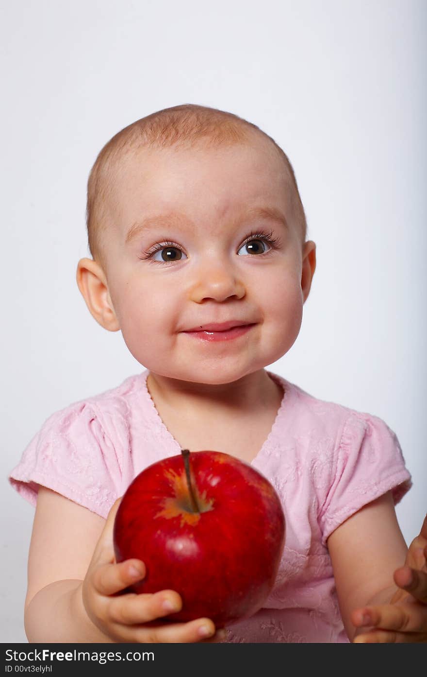 Portrait of happy baby with apple