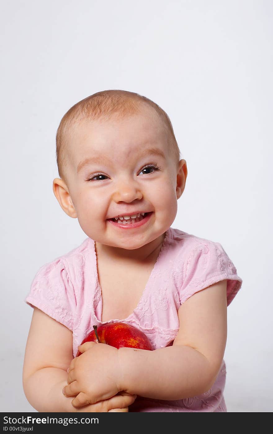 Portrait of happy baby with apple