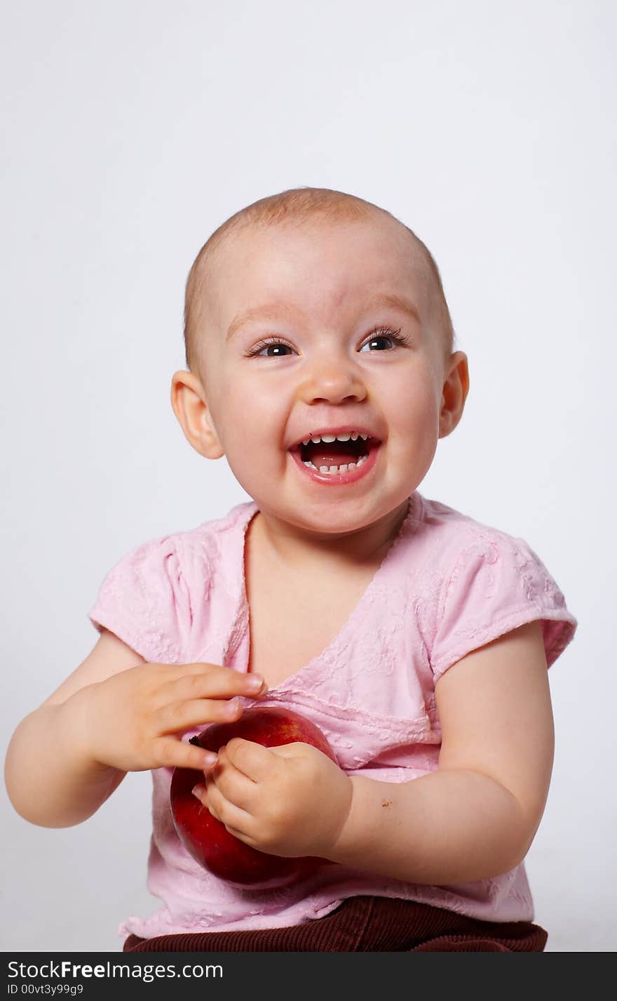 Portrait of happy baby with apple