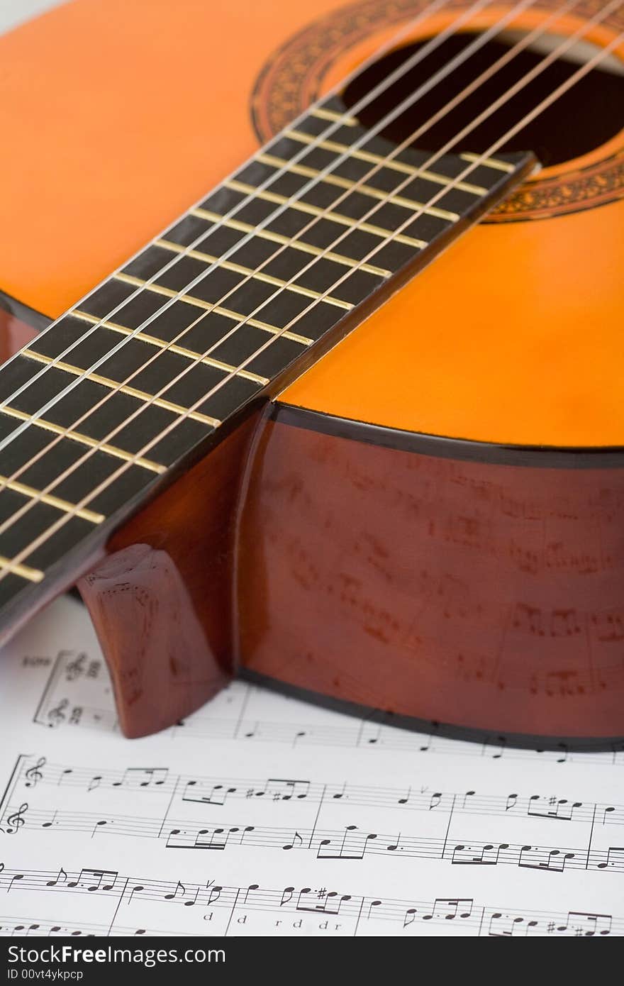 Acoustic guitar and sheet music, close-up