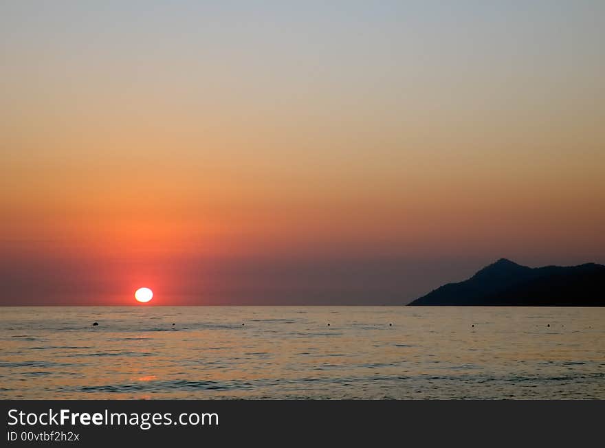 View from a beach red sunset over the Mediterranean sea