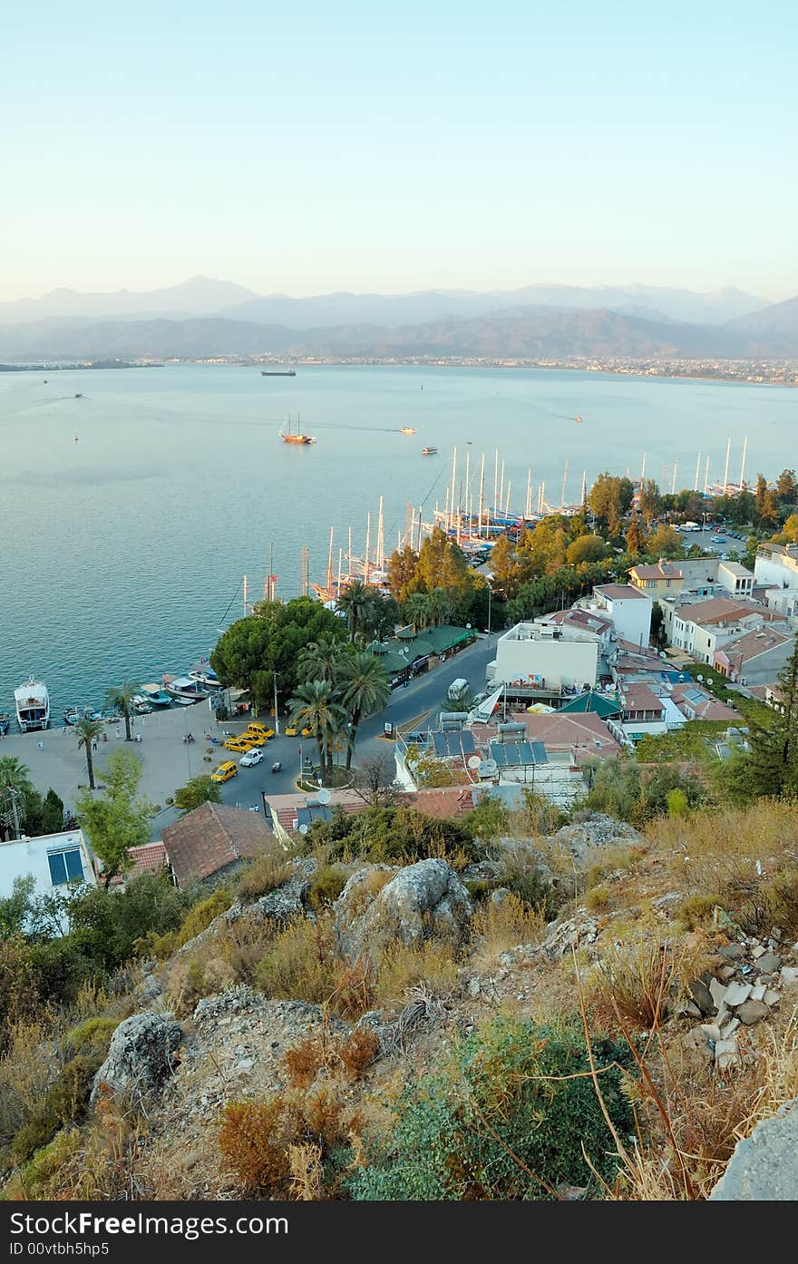 Top-down view on the seaside town and mountains behind sea bay. Top-down view on the seaside town and mountains behind sea bay