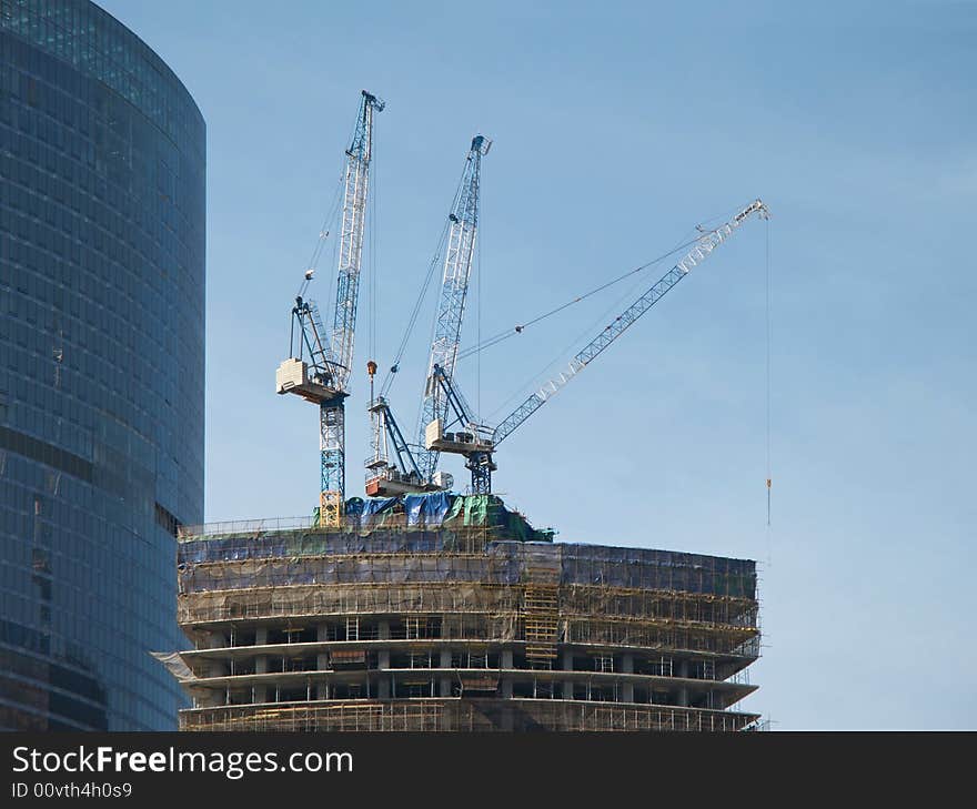 Three lifting cranes on the top of the building been constructed