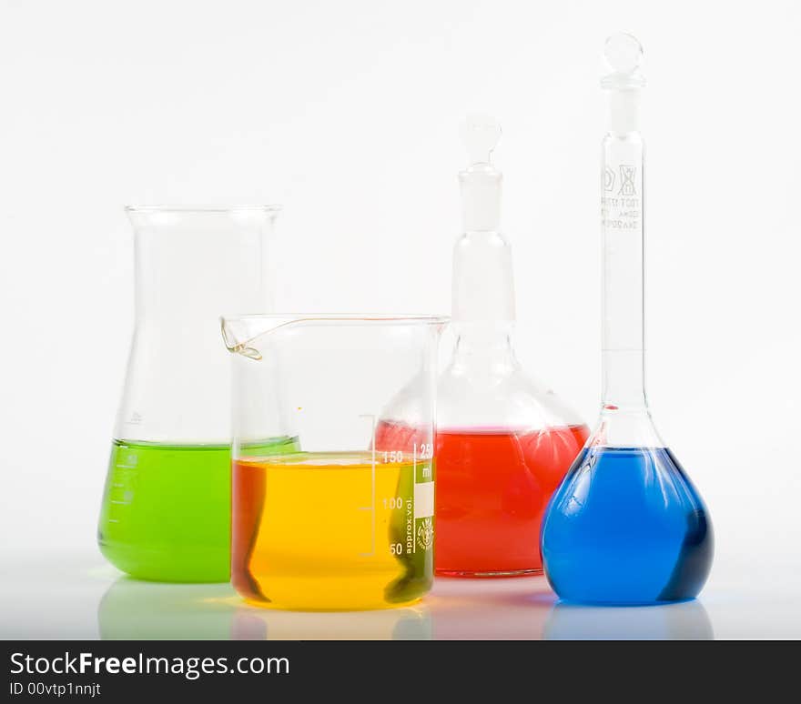 Various colorful flasks over white background