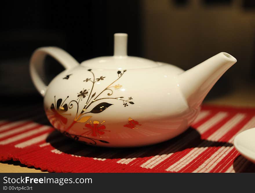 White teapot with beutiful flower pattern