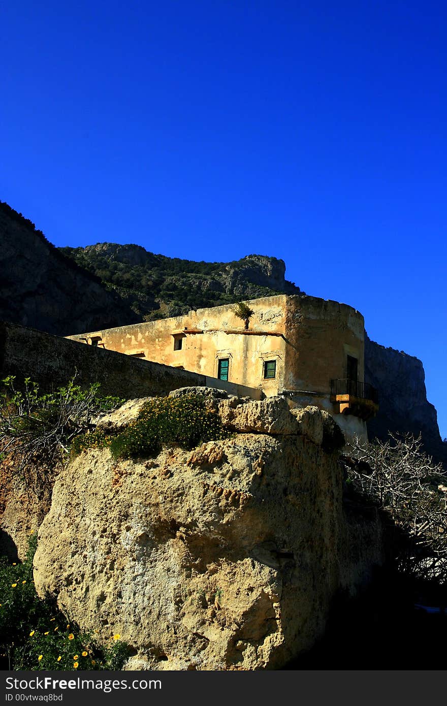 Ancient Tuna fishing construction Tonnara Bordonaro XVI century in Palermo. View on Mount Pellegrino blue sky and sea. Island of Sicily, Italy. Ancient Tuna fishing construction Tonnara Bordonaro XVI century in Palermo. View on Mount Pellegrino blue sky and sea. Island of Sicily, Italy