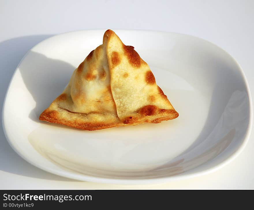 Freshly baked vegetarian Samosa on a white plate