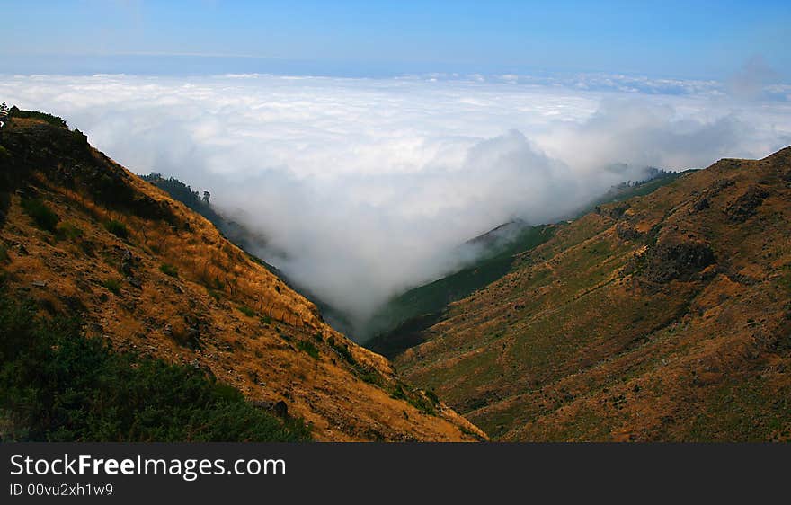 A shot in the mountains of Madiera showing the clouds coming through gaps in two peaks. A shot in the mountains of Madiera showing the clouds coming through gaps in two peaks.