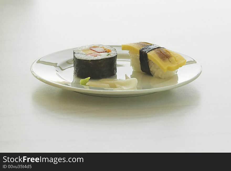 Sushi maki and nigiri with ginger arranged on a plate