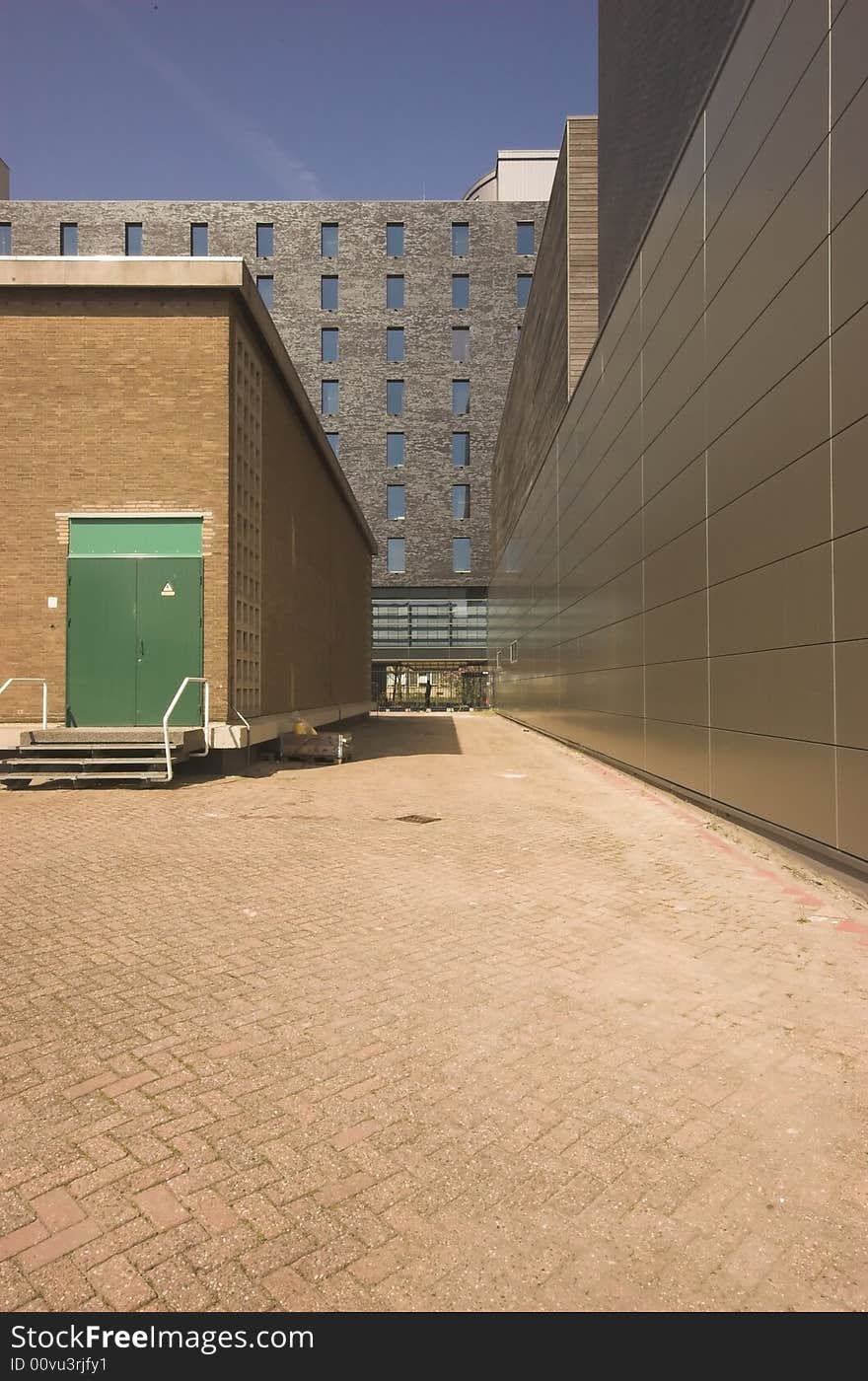 A square in front of a modern office building brightly lit by summer sun