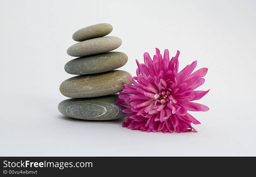 Pyramid from stones with a flower on a white background