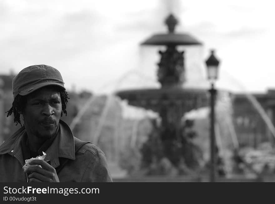 Black man and fountain in background