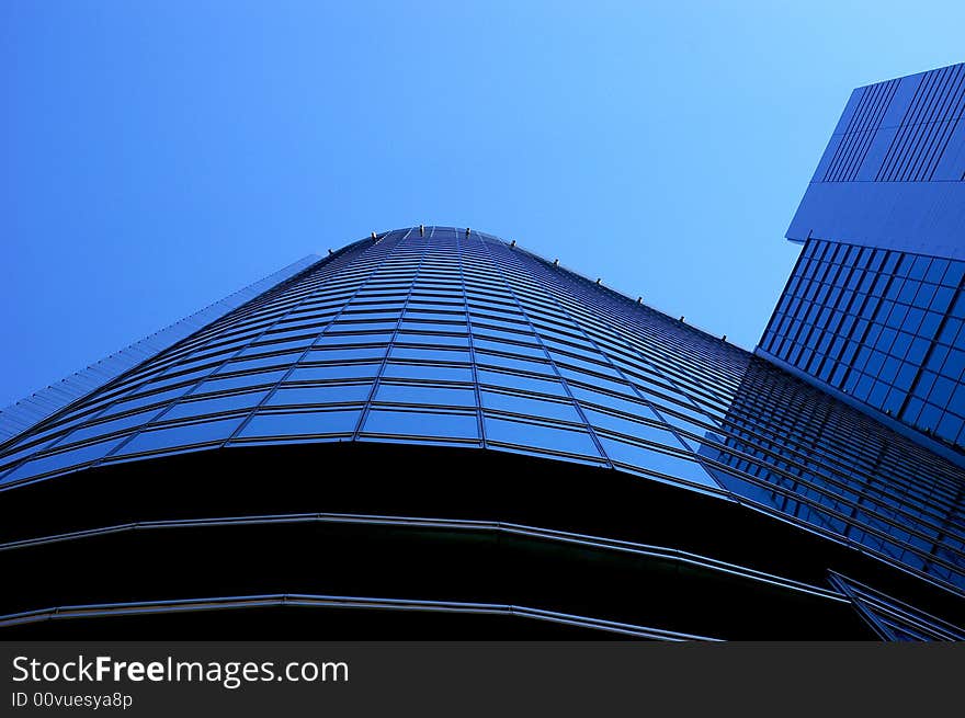 Blue skyscraper glass wall with mirroring windows