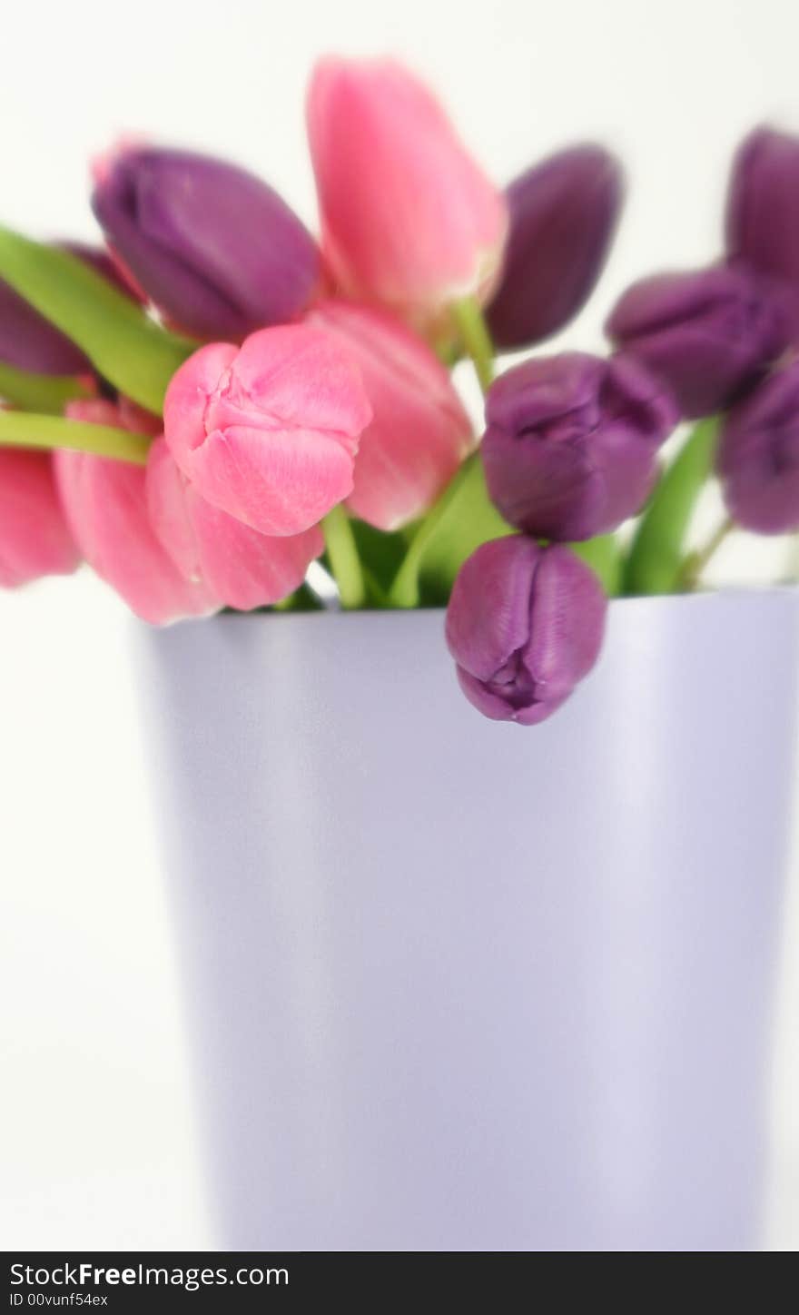 A vase full of purple and pink tulips