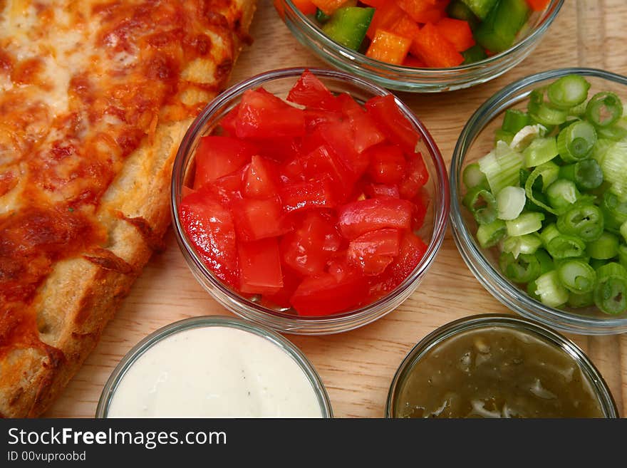 Bowl of diced tomatoes with veggies and cheesebread pizza.