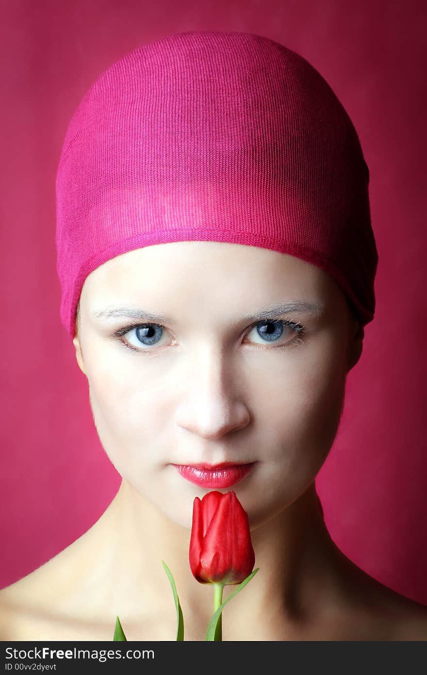 Beauty portrait of a beautiful young woman with a red tulip flower. Beauty portrait of a beautiful young woman with a red tulip flower