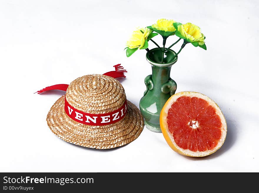 A grapefruit, a hat and flowers